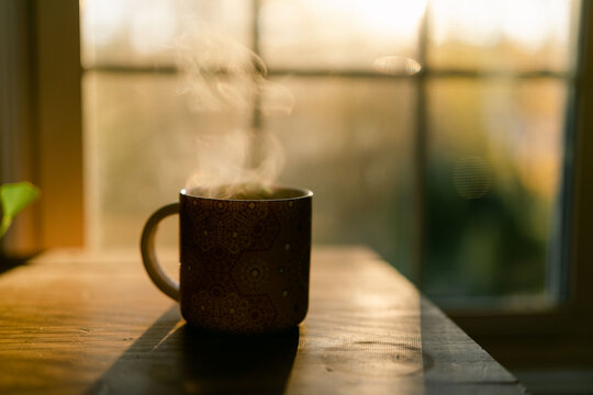 Warm morning light over a mug of tea by a window